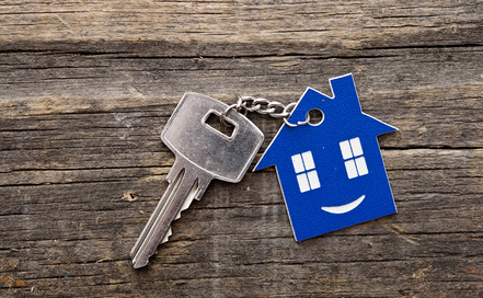 Buying a holiday home - Keychain figure of house and key close up