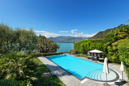 Buying a holiday home - external of a villa, beautiful swimming pool overlooking the lake