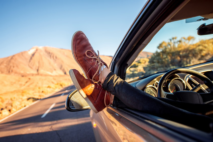 tips for planning a European road trip - Female legs on the vehicle door with casual shoes