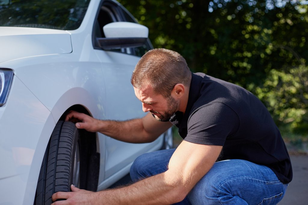 Man examining car tire