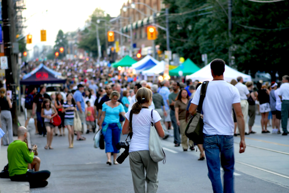 A couple of photographers heading into a crowd at jazz street festival