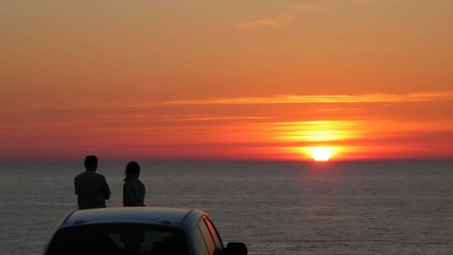 Couple sitting on a car